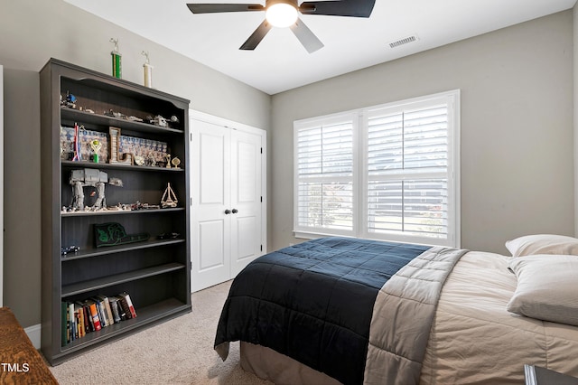 carpeted bedroom featuring visible vents, ceiling fan, and a closet