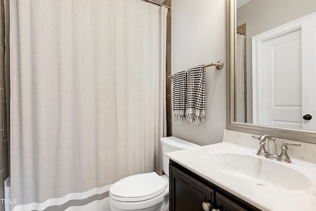 bathroom featuring toilet, walk in shower, and vanity