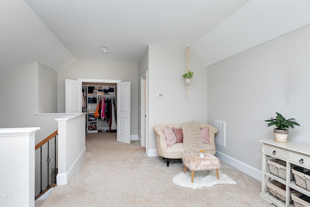 living area featuring light carpet, baseboards, an upstairs landing, lofted ceiling, and visible vents