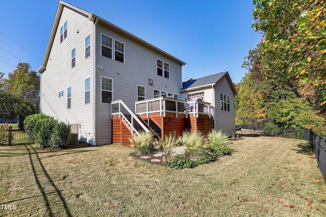 rear view of house featuring a lawn, a wooden deck, stairs, and a fenced backyard