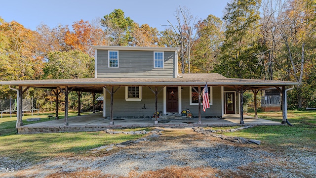 farmhouse inspired home featuring a carport, a front lawn, and a porch