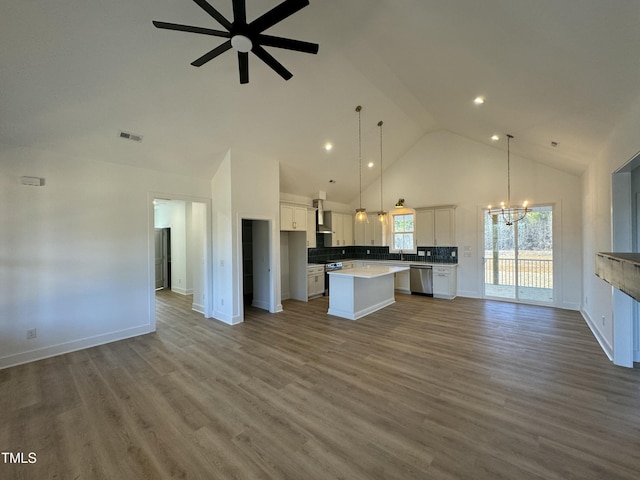 kitchen with a center island, stainless steel appliances, visible vents, open floor plan, and white cabinets