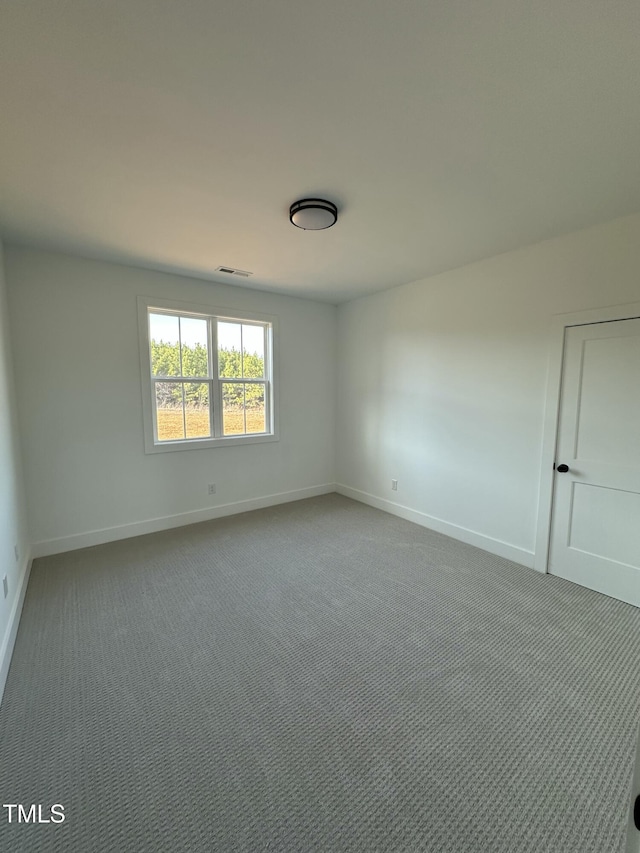 carpeted empty room with visible vents and baseboards