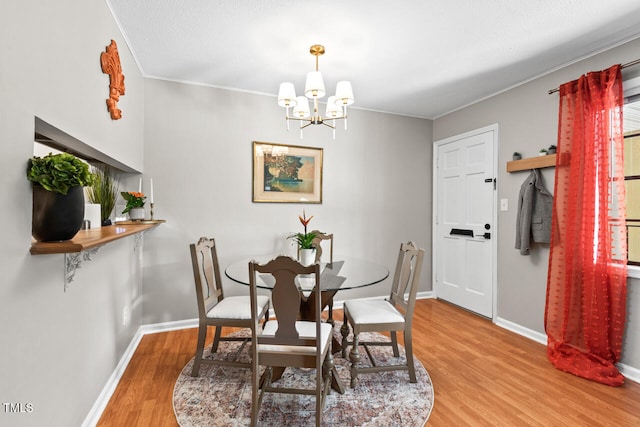 dining room featuring a chandelier, light hardwood / wood-style floors, and ornamental molding