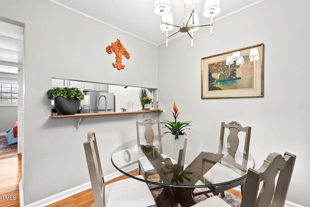 dining space with light wood-type flooring and ornamental molding