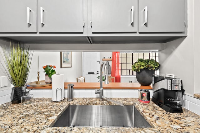 kitchen with light stone countertops and sink