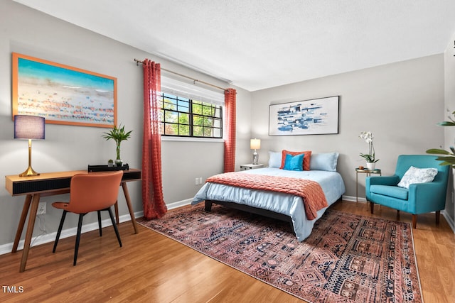 bedroom featuring hardwood / wood-style floors and a textured ceiling