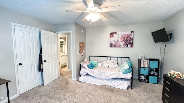 carpeted bedroom featuring ceiling fan and a textured ceiling