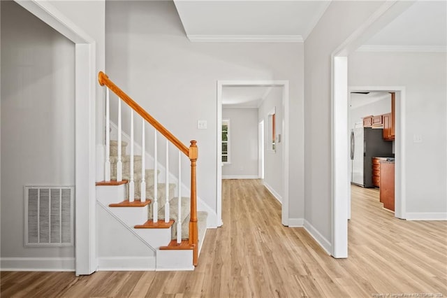 entryway featuring light hardwood / wood-style flooring and ornamental molding