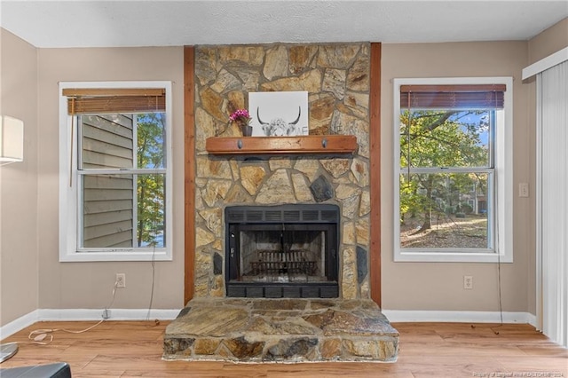 room details with a stone fireplace, a textured ceiling, and hardwood / wood-style flooring