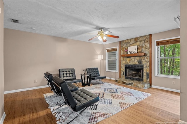 1018 Wood Creek Dr Unit 3, Fayetteville, NC 28314 - living area with wood finished floors, a ceiling fan, a fireplace, and a textured ceiling