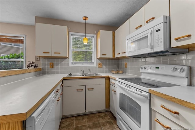 kitchen featuring pendant lighting, white appliances, sink, and plenty of natural light