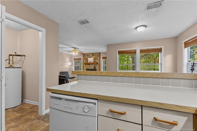 kitchen featuring water heater, a textured ceiling, white dishwasher, and ceiling fan