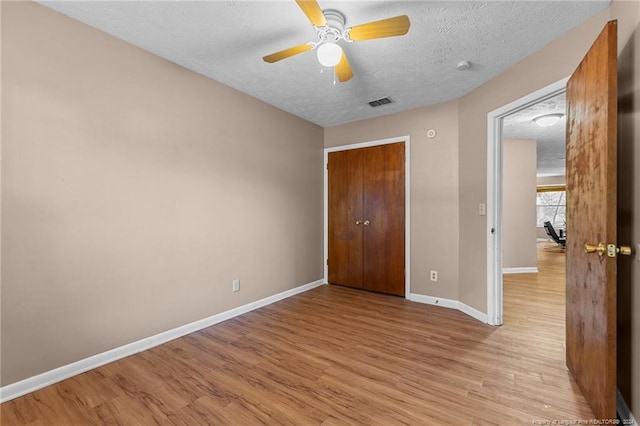 1018 Wood Creek Dr Unit 3, Fayetteville, NC 28314 - unfurnished bedroom featuring light wood-style flooring, a closet, a textured ceiling, and a ceiling fan