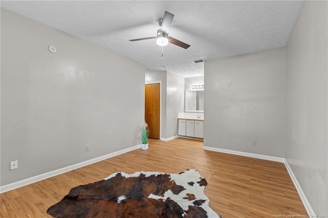 spare room featuring ceiling fan, a textured ceiling, and light wood-type flooring