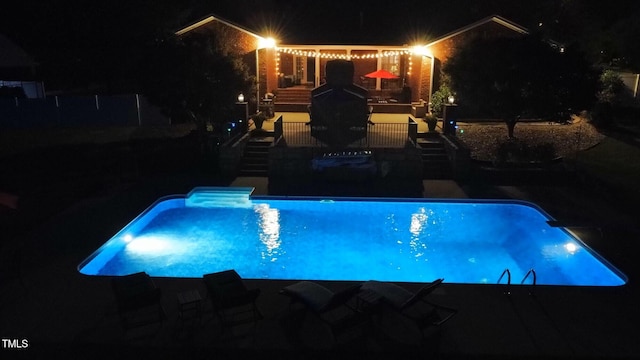 view of pool at twilight