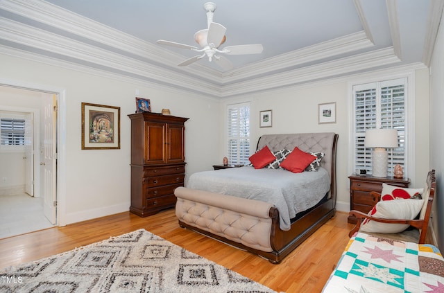 bedroom featuring ceiling fan, ensuite bath, crown molding, and light hardwood / wood-style flooring