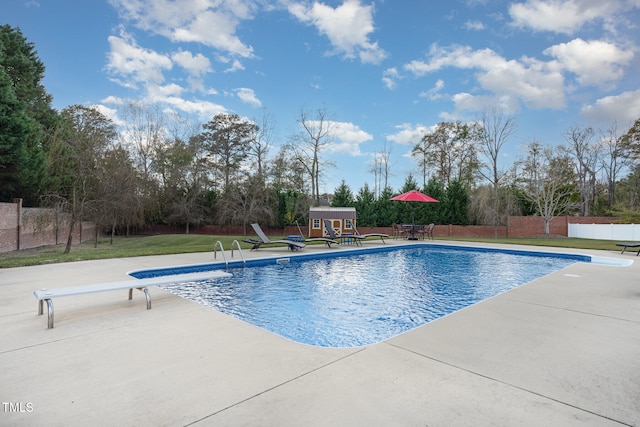 view of pool with a patio, a diving board, an outdoor structure, and a lawn