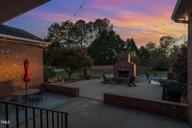 166 Weldon Dr, Clayton, NC 27520 - patio terrace at dusk featuring an outdoor brick fireplace, a patio area, and outdoor dining space