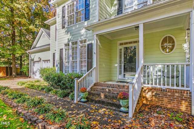 entrance to property featuring covered porch and a garage