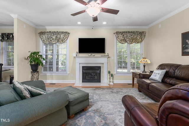 living room featuring light hardwood / wood-style floors, crown molding, and ceiling fan