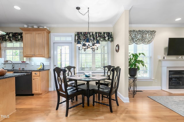 dining area featuring a wealth of natural light, an inviting chandelier, crown molding, and light wood-type flooring