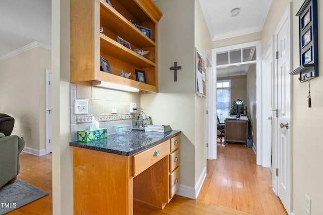 kitchen with backsplash, crown molding, and light wood-type flooring