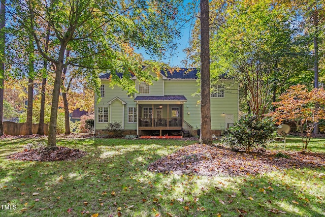 rear view of property featuring a lawn