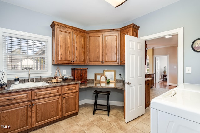 kitchen featuring light tile patterned flooring, sink, and washing machine and clothes dryer