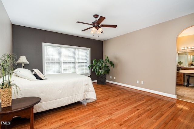 bedroom featuring ensuite bathroom, light hardwood / wood-style floors, and ceiling fan