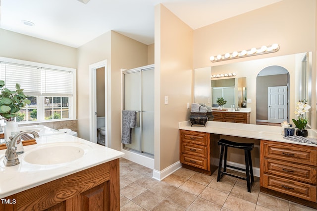 bathroom with an enclosed shower, vanity, tile patterned floors, and toilet