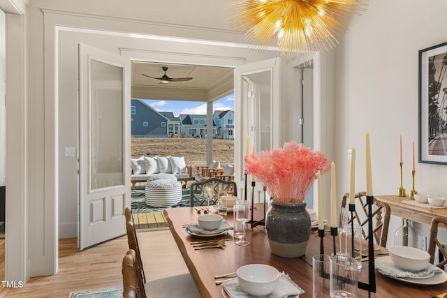 dining area with light hardwood / wood-style flooring, a chandelier, and crown molding