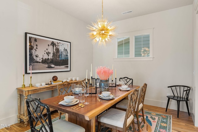 dining room featuring light hardwood / wood-style floors and an inviting chandelier