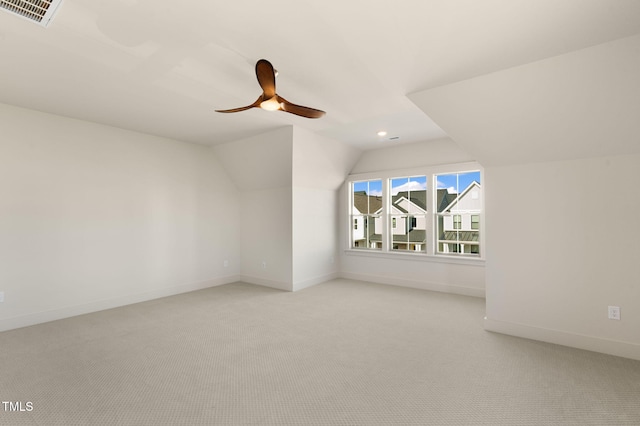 additional living space with ceiling fan, vaulted ceiling, and light colored carpet