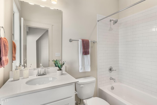 full bathroom with vanity, tiled shower / bath combo, and toilet