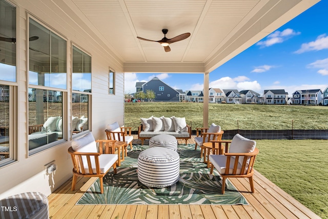 wooden deck with an outdoor living space, a yard, and ceiling fan