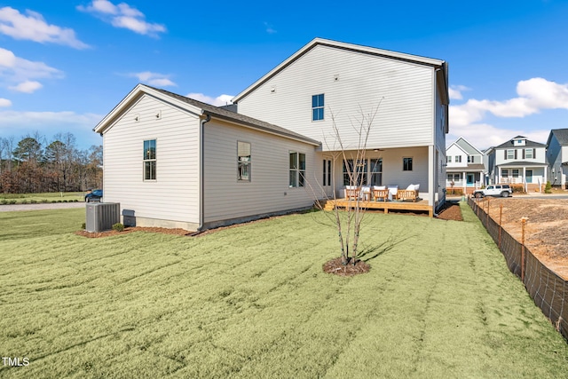 rear view of house featuring a wooden deck, central AC, and a lawn