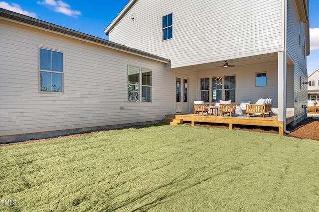 rear view of property featuring a yard, ceiling fan, and a deck