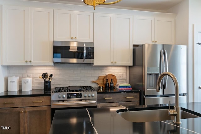 kitchen featuring appliances with stainless steel finishes, white cabinets, and backsplash