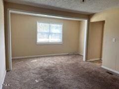 unfurnished bedroom with a textured ceiling and carpet