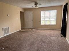 carpeted empty room featuring ceiling fan