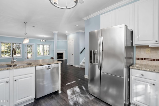 kitchen with stainless steel appliances, a sink, ornamental molding, backsplash, and a fireplace