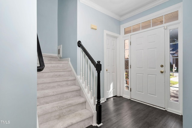 foyer entrance with healthy amount of natural light, dark wood-type flooring, crown molding, stairway, and baseboards
