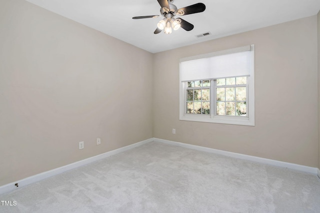 empty room with light colored carpet, baseboards, and a ceiling fan