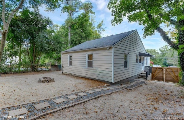 view of property exterior featuring a patio and a fire pit