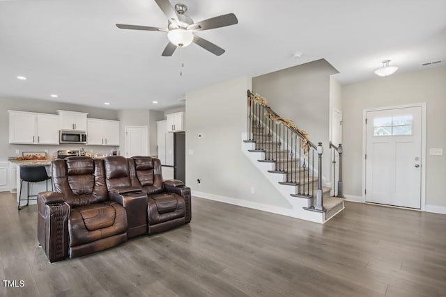 living room with ceiling fan and dark wood-type flooring