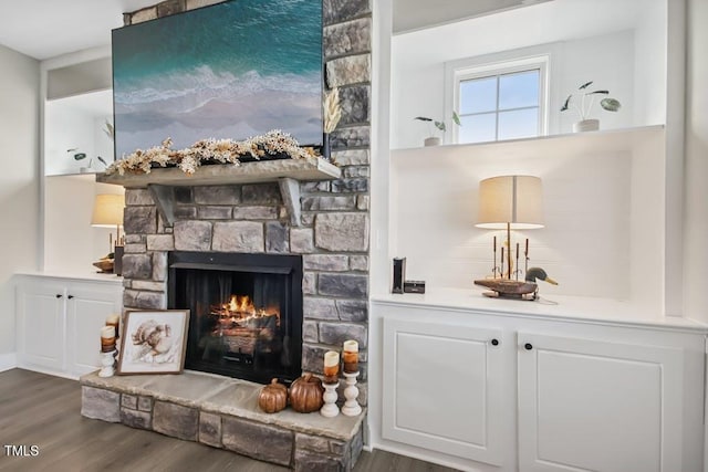 bar featuring a fireplace, dark hardwood / wood-style flooring, and white cabinets