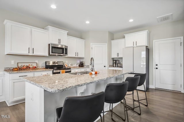 kitchen featuring white cabinetry, sink, dark wood-type flooring, a kitchen island with sink, and appliances with stainless steel finishes