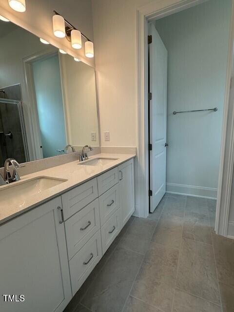 bathroom with vanity and a shower with door