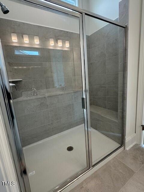 bathroom featuring a shower with door and tile patterned floors